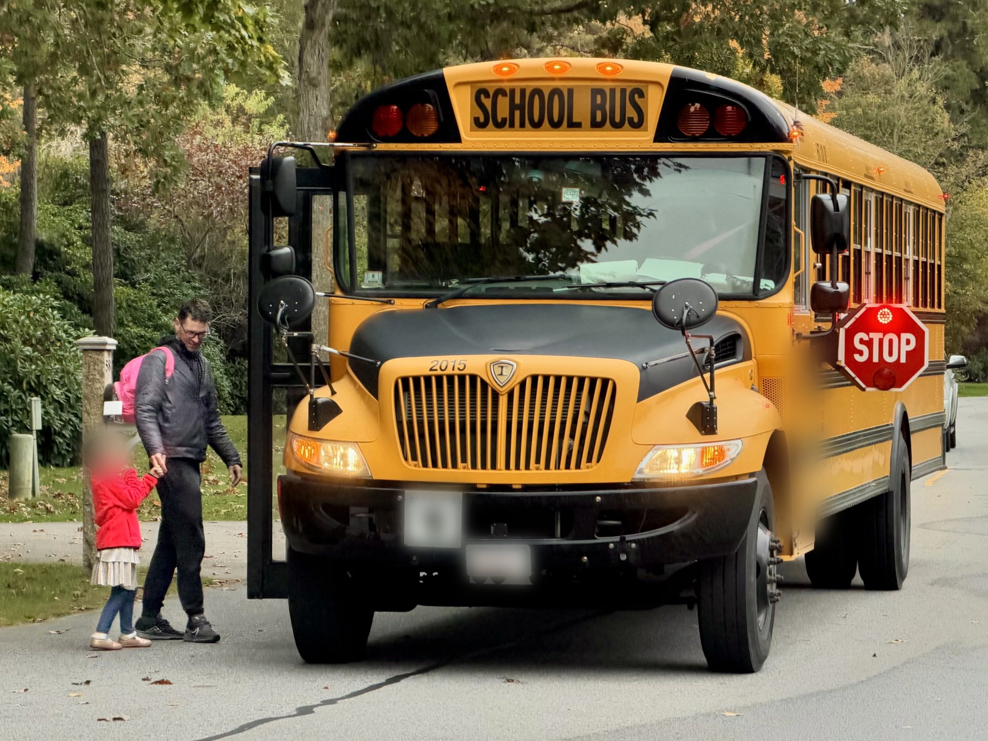 Jeff walking his kid to the school bus, its stop arm out